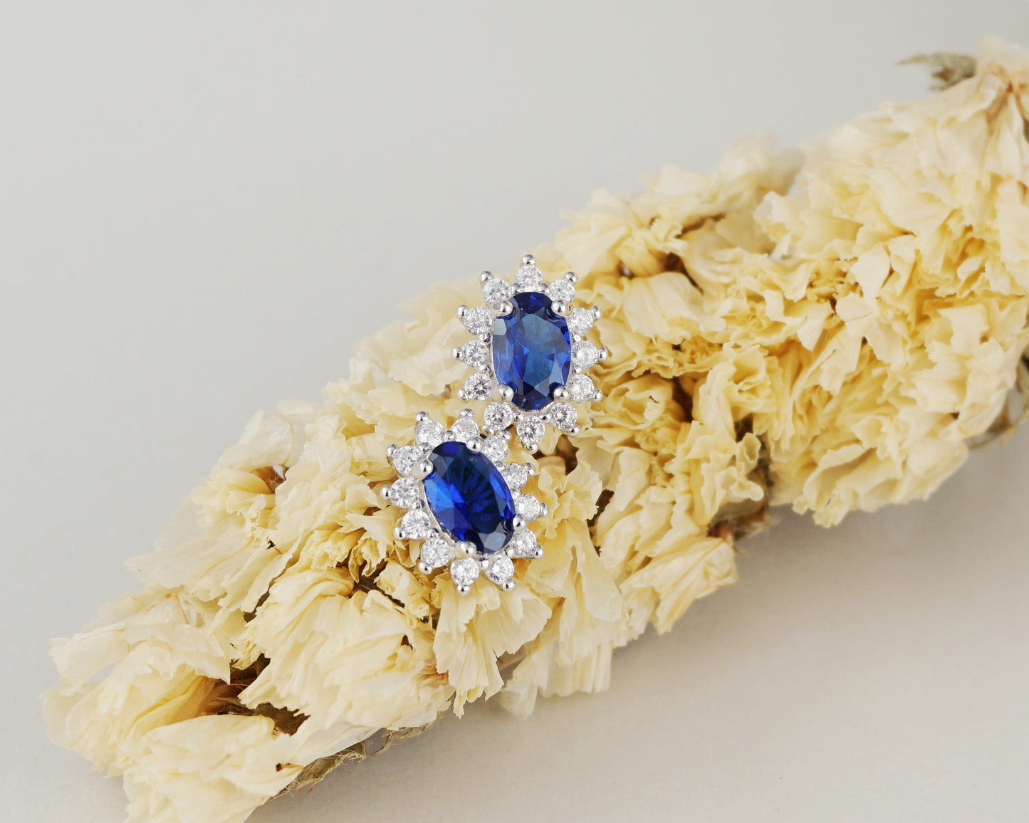 Pair of Halo Oval Sapphire Blue CZ Stud Earrings in Rhodium Plated over Sterling Silver